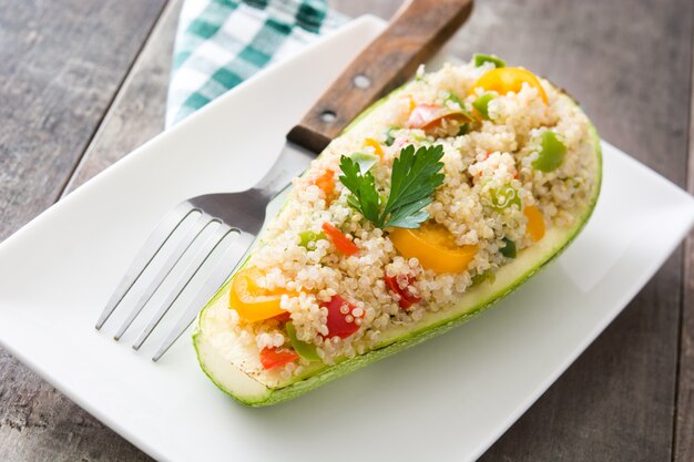 Angefüllte Zucchini mit Quinoa und Gemüse auf Holztisch