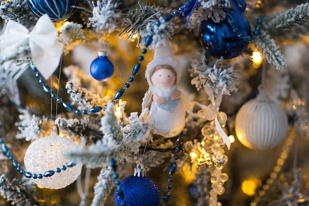 Foto Ángel colgando de un árbol decorado