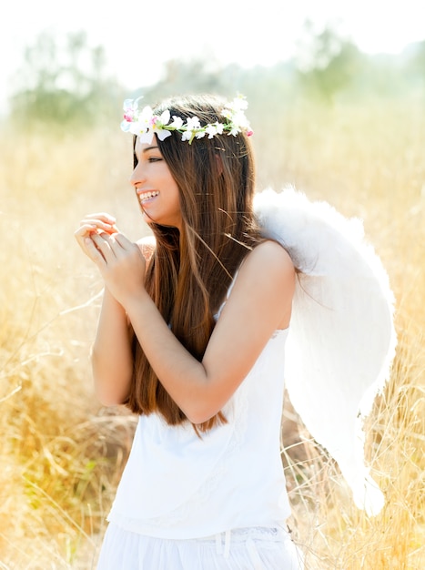 Angel girl en campo de oro con alas de plumas blancas