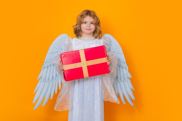 Foto Ángel niño sostenga regalo presente día de san valentín niño con alas de ángel retrato de estudio de niño ángel en