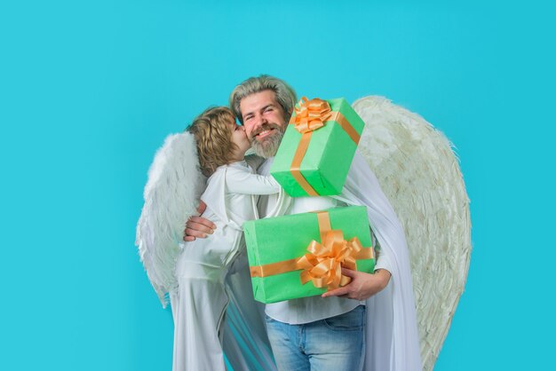 Los ángeles de san valentín cupido niño le da a padre regalo padre disfrazado de ángel con angelito hijo