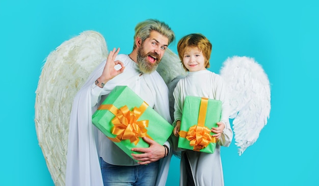 Angelito niño con regalo y hombre barbudo en alas angelicales muestra signo ok día de san valentín compras