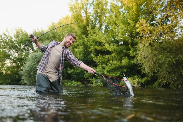 Angeln Fischer und Forelle Fischer am wilden Fluss