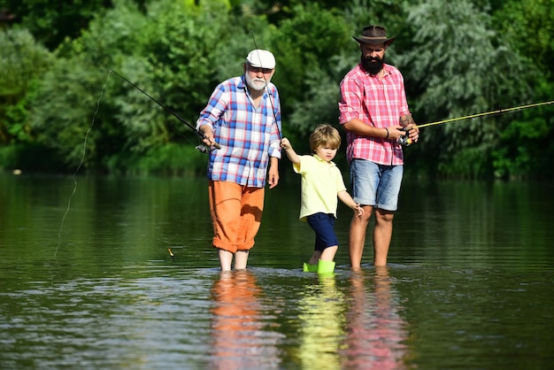 Angeln Fliegenfischen des kleinen Jungen auf einem See mit seinem Vater und Großvater Glücklicher Großvater und Enkel fischen auf dem Fluss Männerhobby