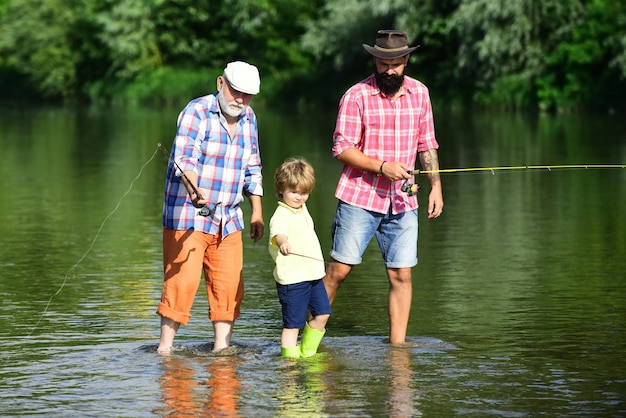 Angeln kleiner Junge Fliegenfischen im Fluss mit seinem Vater und Großvater