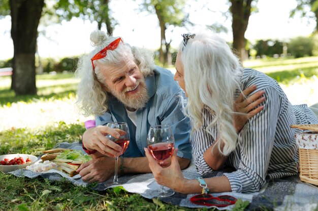 Angenehme Kommunikation. Erfreutes nettes Paar, das Wein genießt und ein angenehmes Gespräch führt