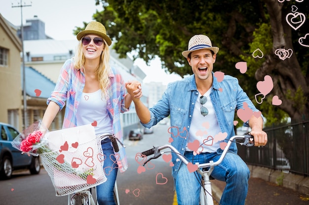 Angesagtes junges Paar, das eine Radtour gegen das Valentinstag-Herzdesign anstrebt