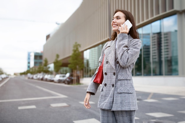 Angestellte Dame spricht auf Smartphone und führt Gespräche im Freien