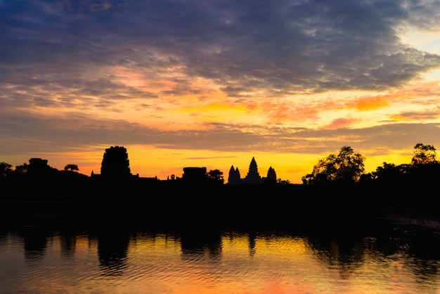 Angkor Wat céu dramático na reflexão de silhueta de fachada principal de amanhecer na lagoa de água