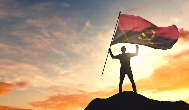 Angola-Flagge wird von einem Mann geschwenkt, der Erfolg auf der Spitze eines Berges feiert 3D-Rendering