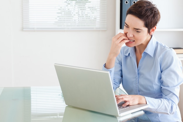 Angry brunette Geschäftsfrau mit einem Laptop