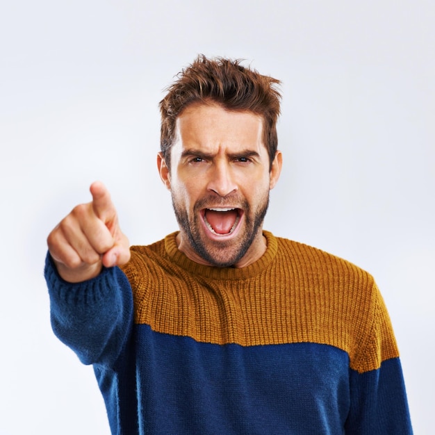 Angry man Porträt und zeigt auf Sie mit Schrei für die Wahl wählen oder Frustration auf einem grauen Studio-Hintergrund Frustrierte männliche Person oder Modell schreien oder schreien mit Stimmung oder Haltung auf Mockup