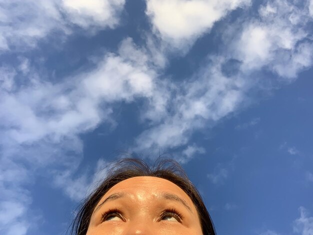 Foto Ângulo baixo de mulher olhando para o céu