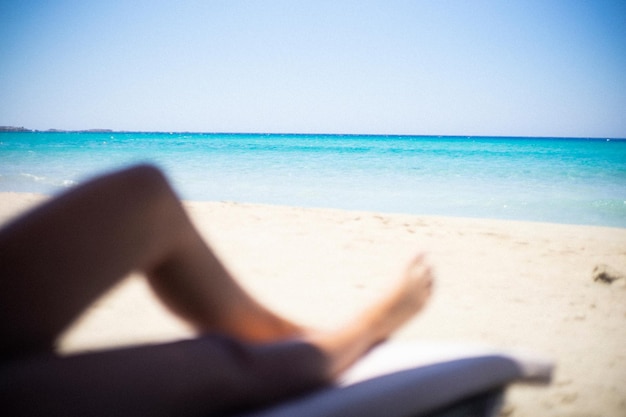 Foto Ángulo baixo de mulher relaxando na praia