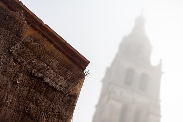 Foto Ángulo bajo de la torre de una antigua iglesia católica en un día de niebla