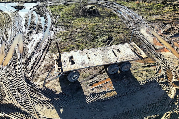 Anhänger zum Transport von Brettern und schweren Baumaterialien auf der Baustelle LKW oder Anhänger im Feld Ansicht von oben Drohnenfotografie Hilfsgeräte