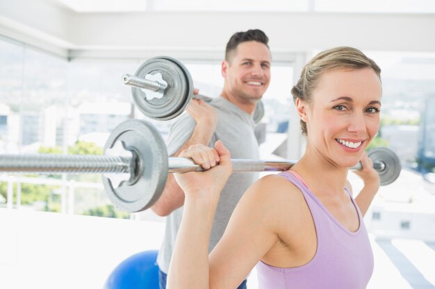 Anhebende Barbells der Frau und des Mannes