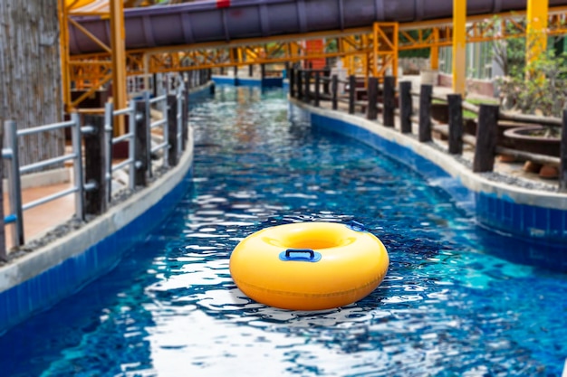 Anillo amarillo flotando en una ola de agua azul en el canal en la piscina Vacaciones de verano