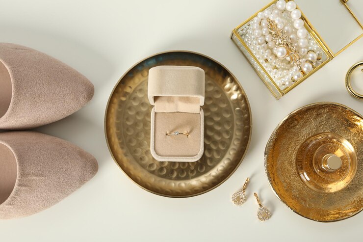 Anillo de bodas en caso de joyas y zapatos en la vista superior de fondo blanco