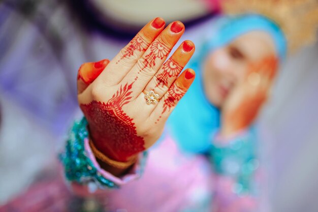 Foto un anillo de bodas y henna en el dedo de la novia