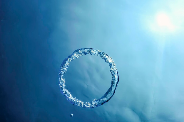 Anillo de burbujas bajo el agua asciende hacia el sol