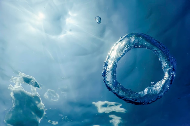 Anillo de burbujas bajo el agua asciende hacia el sol