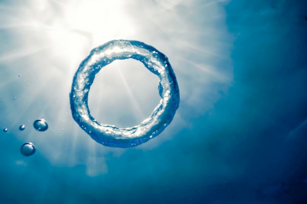 Foto anillo de burbujas bajo el agua asciende hacia el sol