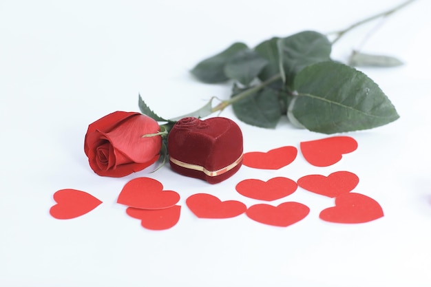 Anillo en caja roja con una rosa roja sobre fondo blanco.