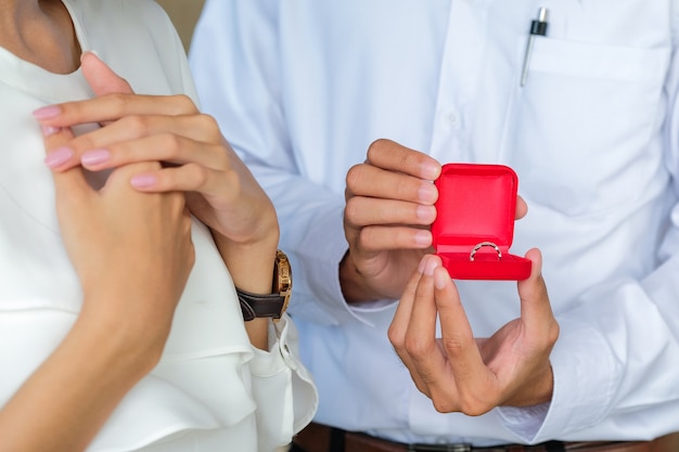 Anillo de diamantes en caja roja a mano para pareja