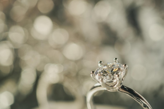 Anillo de diamantes de compromiso de lujo con fondo claro abstracto bokeh