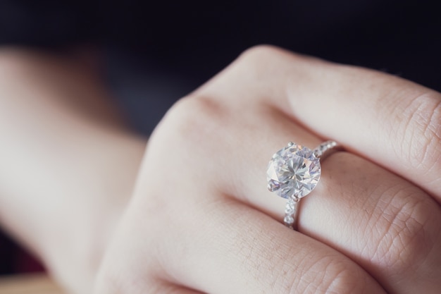 Anillo de diamantes de compromiso en primer plano de dedo de mujer