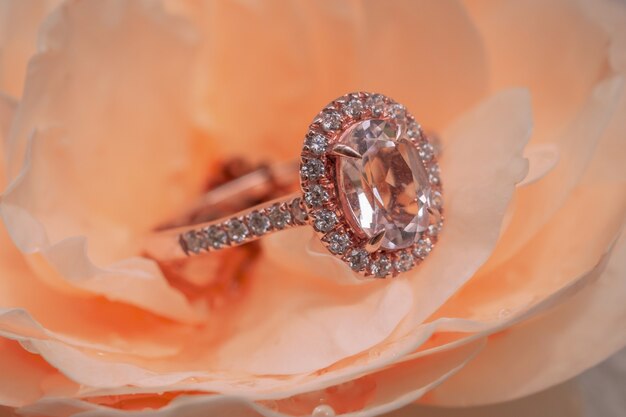 Foto anillo de diamantes rosa sobre fondo de flor rosa