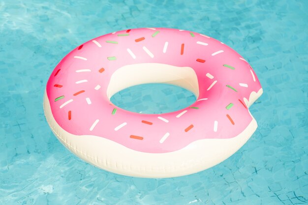 Anillo de natación inflable en forma de rosquilla flotando en piscina