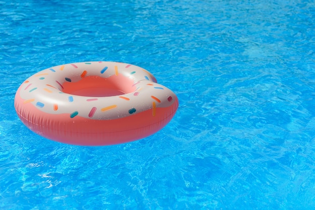 Anillo de natación de rosquilla inflable rosa en una piscina