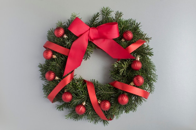 Anillo de Navidad o corona con bolas rojas sobre fondo gris. Vista superior. De cerca.