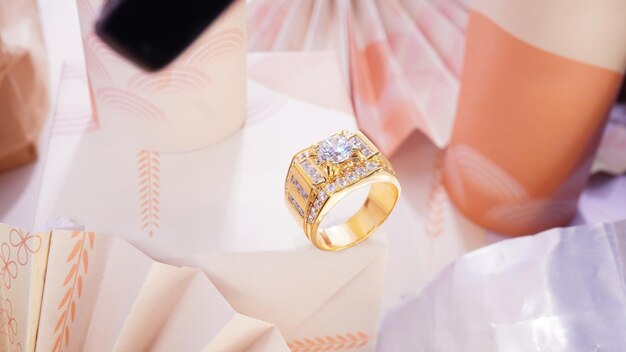 Un anillo de oro sobre fondo de seda con cinta de oro joyería de moda de boda para ella