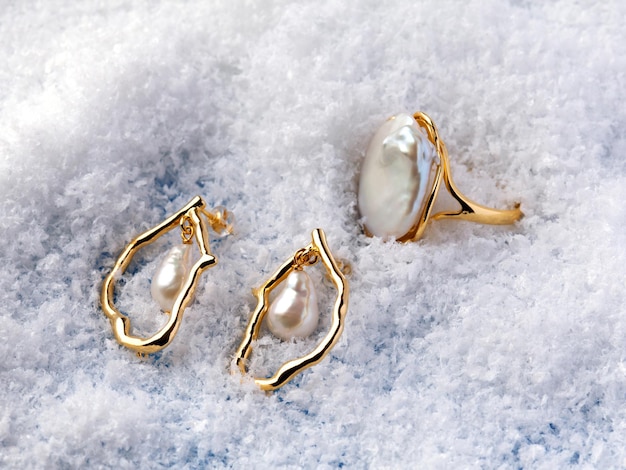 Anillo y pendientes de perlas barrocas elegantes de lujo sobre fondo blanco de nieve. Fotografía de cerca