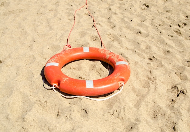 Foto anillo de seguridad para equipos de salvamento de la playa en la arena.