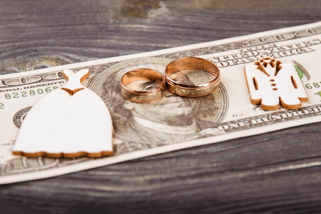Foto anillos de boda en los billetes de 100 dólares. concepto de gastos de boda.