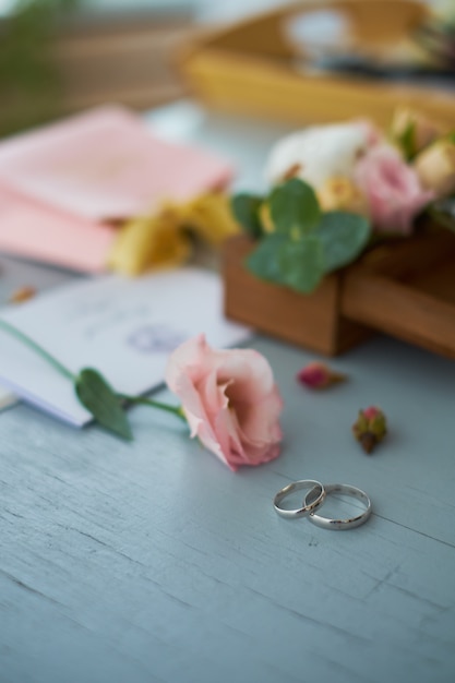 Los anillos de boda cerca de la invitación de la boda.