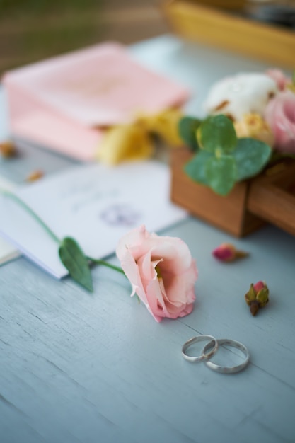 Los anillos de boda cerca de la invitación de la boda.