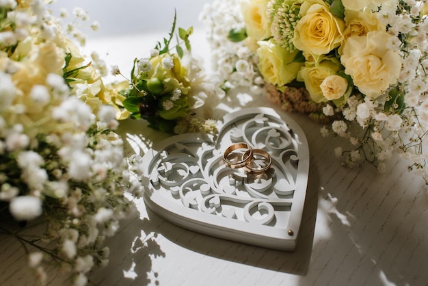 Foto anillos de boda con decoraciones en los preparativos del día de la boda.