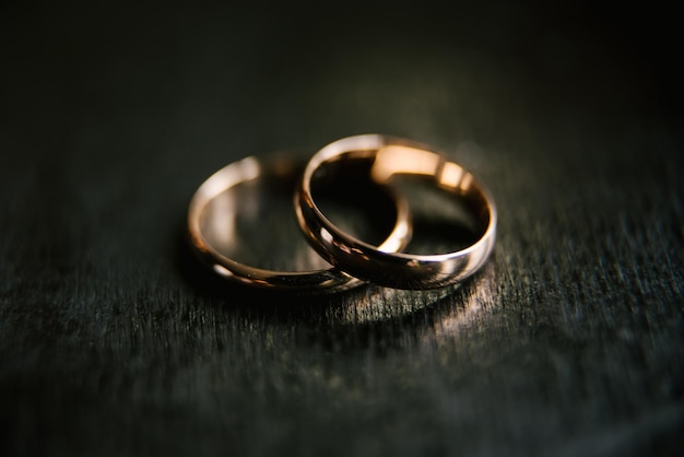 Anillos de boda elegantes para la novia y el novio en un fondo negro con enfoque selectivo macro destacado