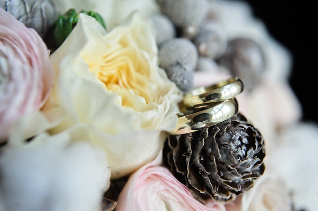 Anillos de boda en el fondo del ramo de novia