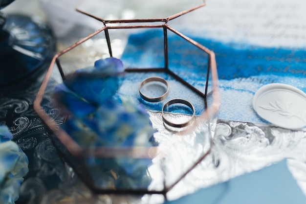 Anillos de boda en invitación de boda con decoraciones. Foto de alta calidad