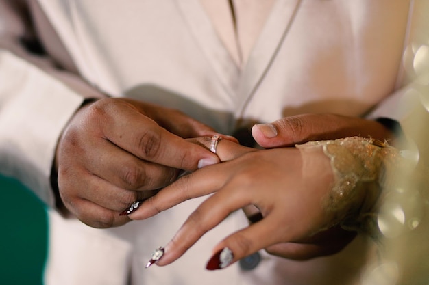 Anillos de boda en manos de la novia y el novio Use un anillo de amor pareja