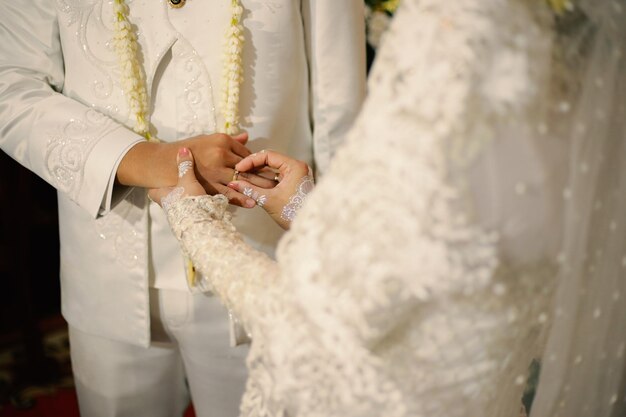 Anillos de boda en manos de la novia y el novio Use un anillo de amor pareja