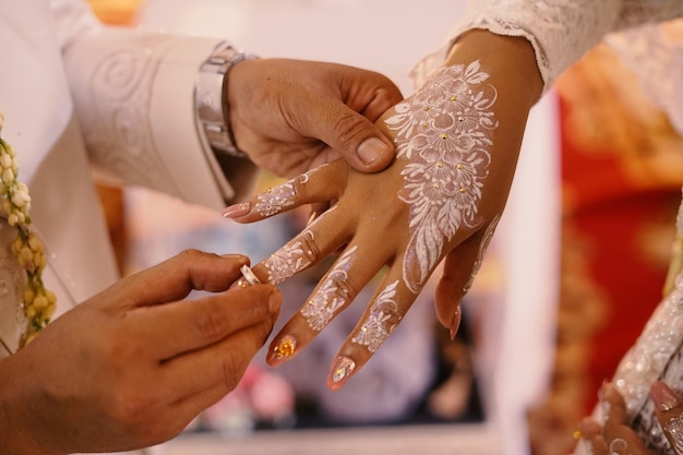 Anillos de boda en manos de la novia y el novio Use un anillo de amor pareja