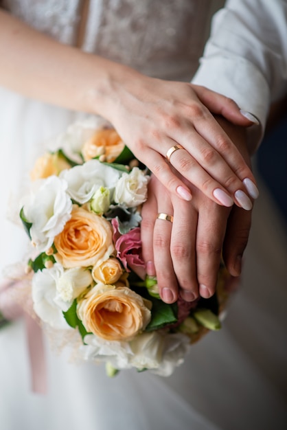 Anillos de boda en manos de los recién casados.