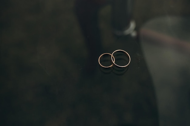 Anillos de boda en una mesa sobre un fondo oscuro